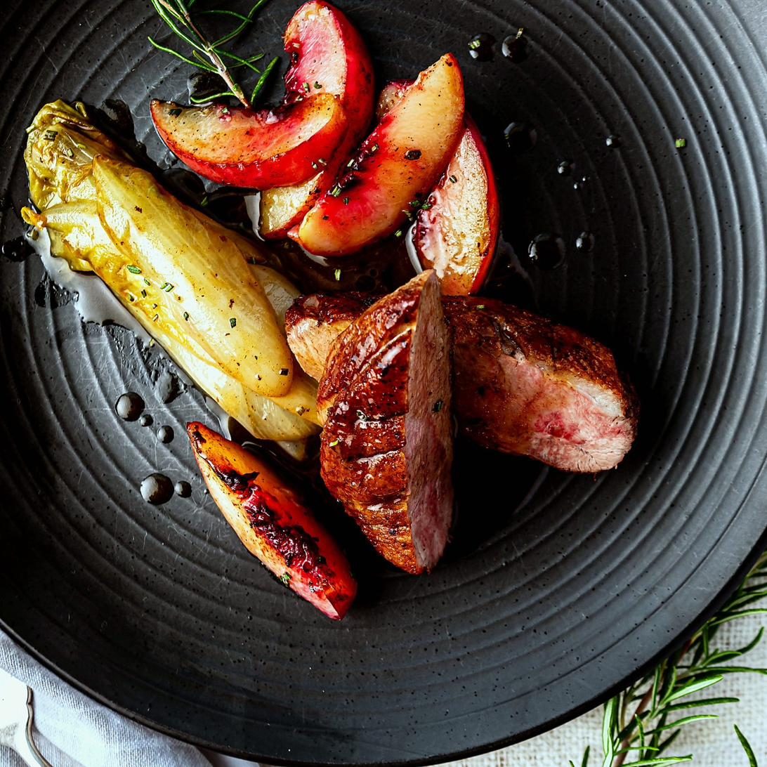 Roasted duck breast with peach and chicory lettuce